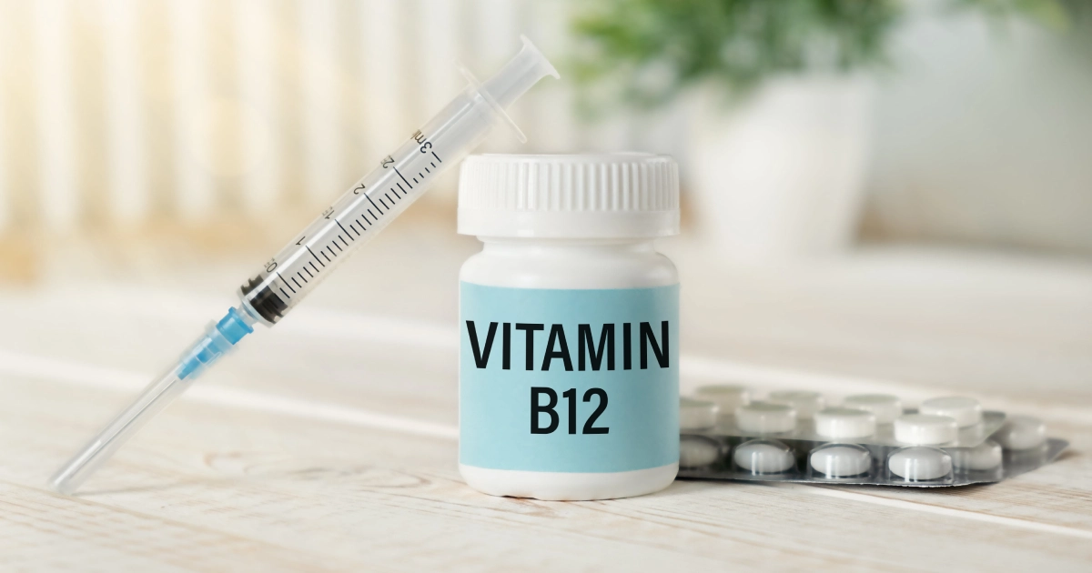 A syringe next to a bottle labeled VITAMIN B12 in Scottsdale, AZ, and a blister pack of white pills.